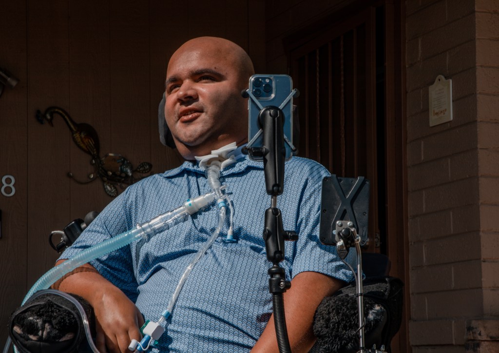 Asim Dietrich, a lawyer for Disability Rights Arizona and a voter in Maricopa County, at his Phoenix home. Dietrich said his signature has changed over time as he has experienced paralysis due to muscular dystrophy. Photo by Noemí Gonzalez for Votebeat