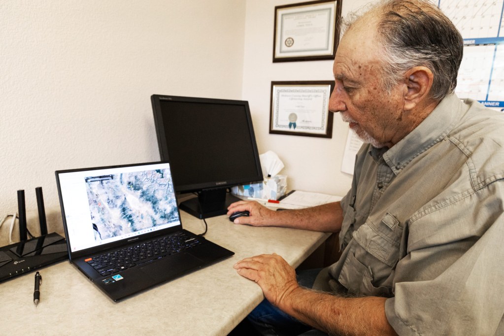 Luis Vega, a Kingman resident and geologist, points out the geological boundaries beneath the Hualapai Valley Basin, where much of the city and nearby nut orchards draw their water. Photo by Christopher Lomahquahu | AZCIR.